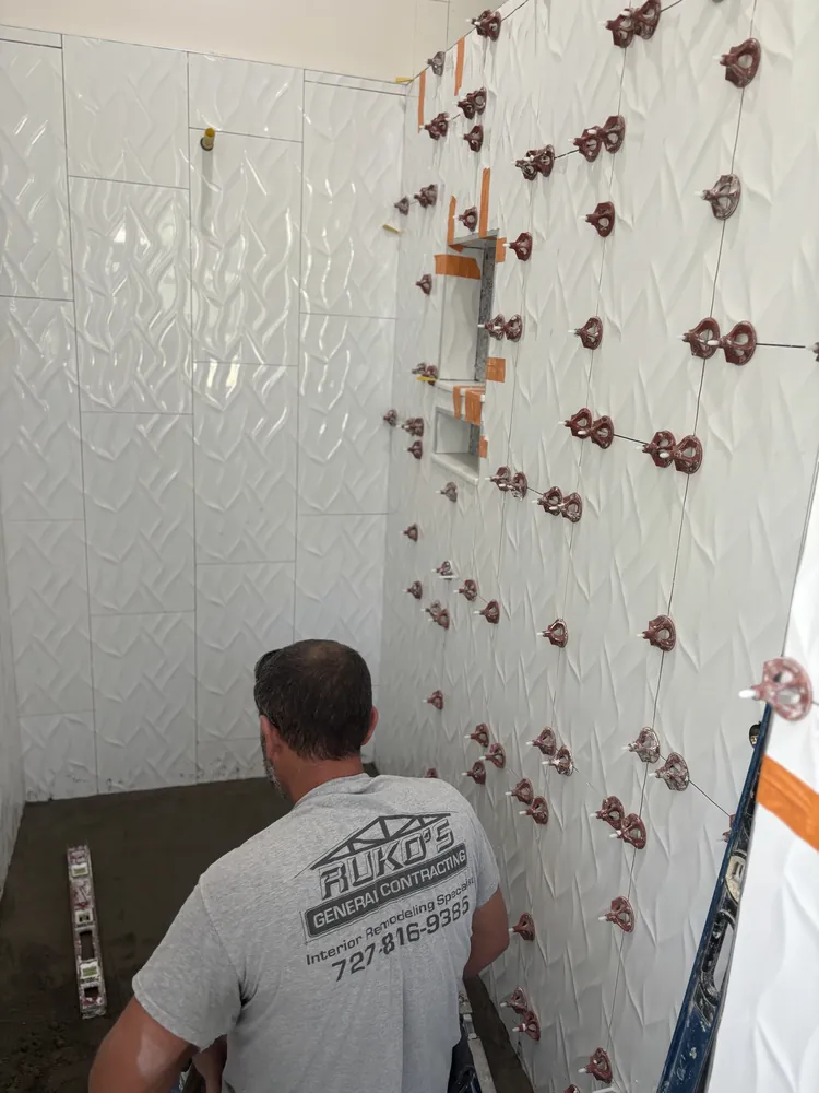 Ruko's General Contracting installer setting large-format wall tile